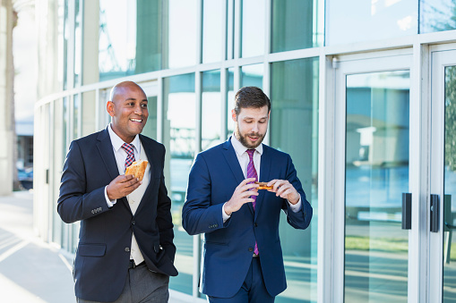 Businessmen Eating Lunch On The Go Stock Photo - Download Image Now