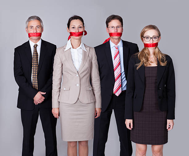 Businesspeople bound by red tape Businesspeople bound by red tape around their mouths standing in a row unable to speak or divulge information human mouth gag adhesive tape women stock pictures, royalty-free photos & images