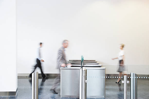 Businesspeople walking through turnstile  returning stock pictures, royalty-free photos & images