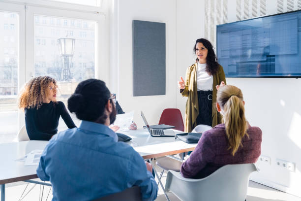 Businesswoman addressing colleagues at a corporate business meeting stock photo
