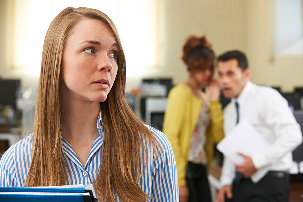Businesswoman Being Gossiped About By Colleagues In Office stock photo