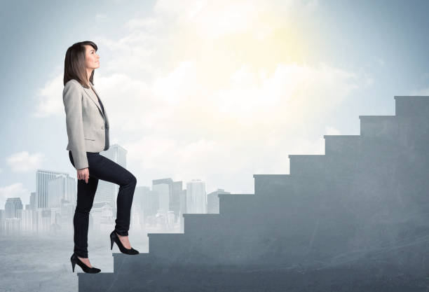 Businesswoman climbing up a concrete staircase concept stock photo