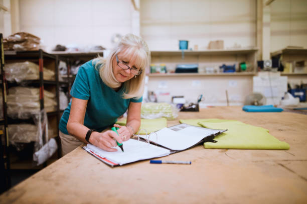 Businesswoman Doing Paperwork In Factory stock photo