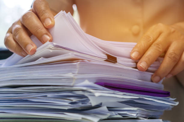 Businesswoman hands working in Stacks of paper files for searching information on work desk office, business report papers,piles of unfinished documents achieves with clips indoor,Business concept  paperwork stock pictures, royalty-free photos & images