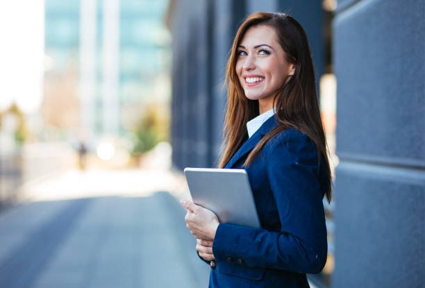 Businesswoman holding digital tablet and smiling stock photo