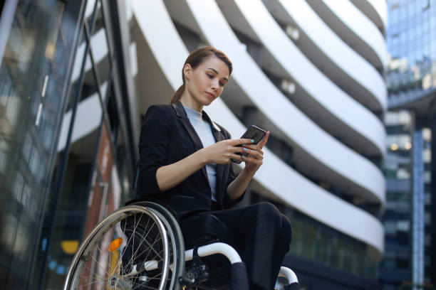 Businesswoman in a wheelchair using a mobile app stock photo