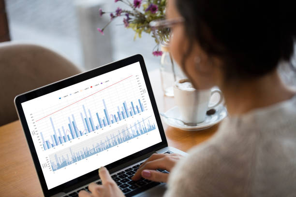 Businesswoman looking Financial Charts on laptop Businesswoman looking Financial Charts on laptop stock market usa stock pictures, royalty-free photos & images