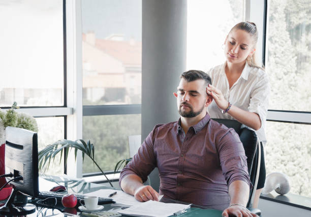 Businesswoman massaging shoulders to colleague at office. Office massage. stock photo