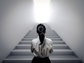 istock businesswoman standing at staircase 1288332068