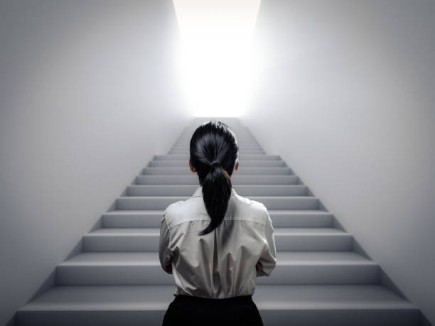 businesswoman standing at staircase stock photo
