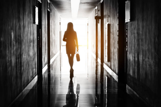 Businesswoman through the office corridor Businesswoman through the office corridor. leaving stock pictures, royalty-free photos & images