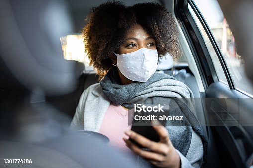 istock Businesswoman traveling by taxi during COVID-19 pandemic 1301774186