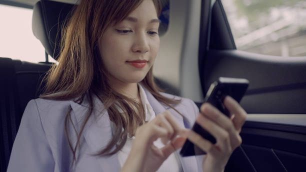 Businesswoman uses a mobile phone in the car stock photo