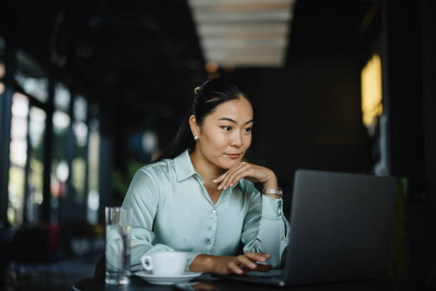 Businesswoman using laptop in the cafe stock photo