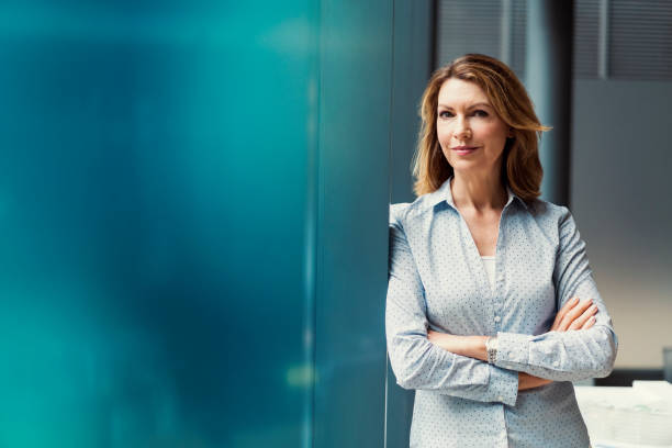 Businesswoman with arms crossed at office stock photo