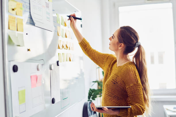 Businesswoman writing on whiteboard in office stock photo