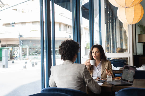 Businesswomen having coffee in cafeteria Businesswomen having coffee in cafeteria alcove window seat stock pictures, royalty-free photos & images