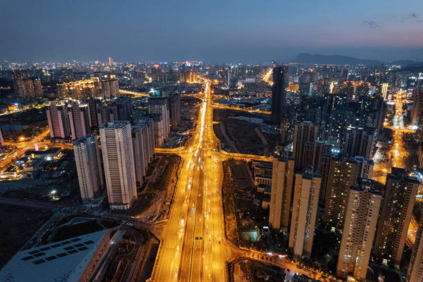 Bustling city high-rise buildings neon lights fast lanes night skyline stock photo