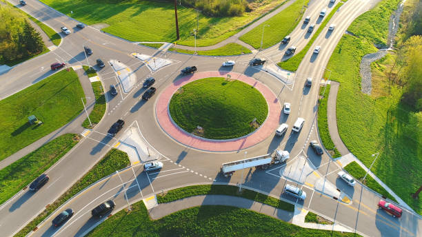 Busy city roundabout intersection at sunrise rush hour. stock photo
