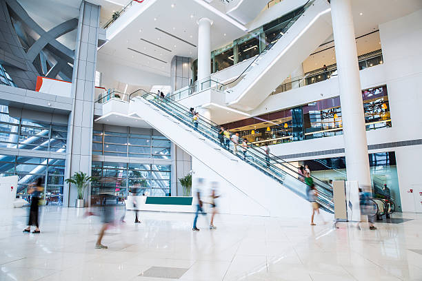 busy shopping mall busy shopping mall, long exposure time, shoppers moving are deliberately blurred shopping mall photos stock pictures, royalty-free photos & images