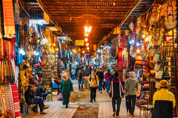 Busy street in the souks of Marrakech, Morocco People are walking in one of narrow streets in the souk of Marrakech, Morocco. souk stock pictures, royalty-free photos & images