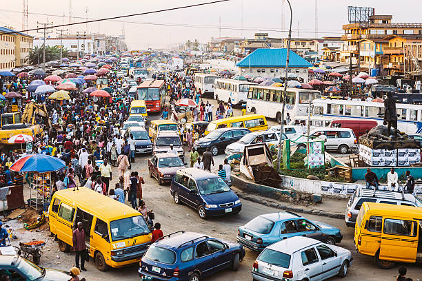 Traffic and street market in Ikorodu district just before sunset.