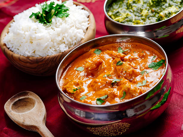 Butter chicken and Saag Paneer Indian dinner Photo of an Indian meal of Butter Chicken, rice and Saag Paneer. Focus across the Butter Chicken bowl. indian food stock pictures, royalty-free photos & images