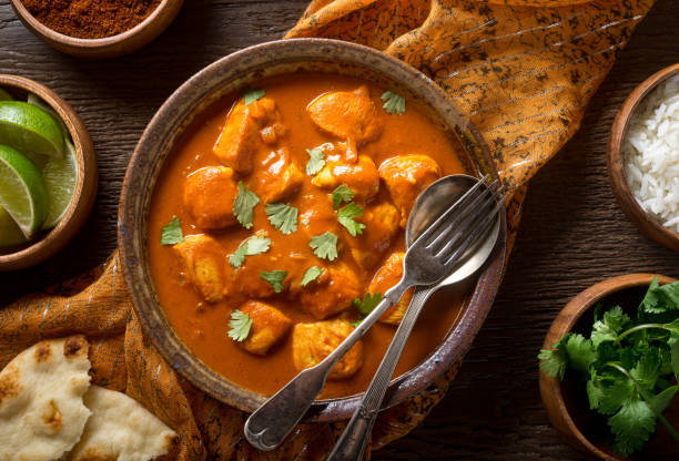 Butter Chicken Curry A bowl of delicious indian butter chicken curry with naan bread, basmati rice, and cilantro garnish. comfort food stock pictures, royalty-free photos & images