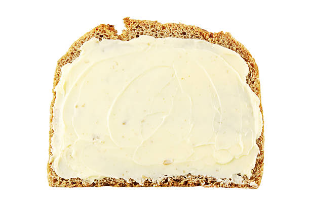 A buttered piece of bread isolated on a white background stock photo