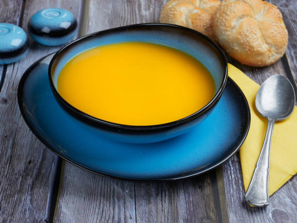 Butternut squash soup in a blue bowl stock photo