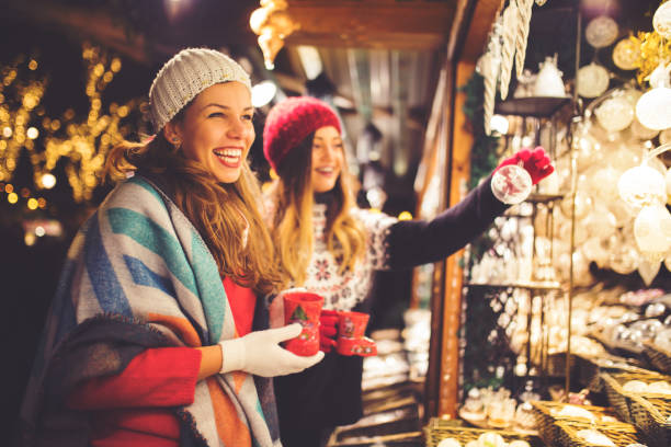 Buying on Christmas market Girl friends having fun and enjoying on Christmas market austria photos stock pictures, royalty-free photos & images