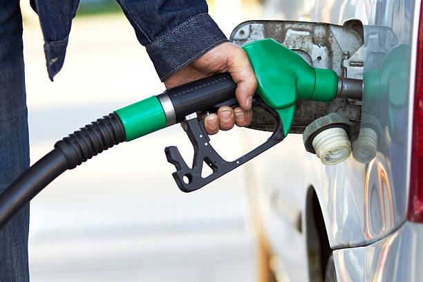 Buying Unleaded petrol global warming car stock photo