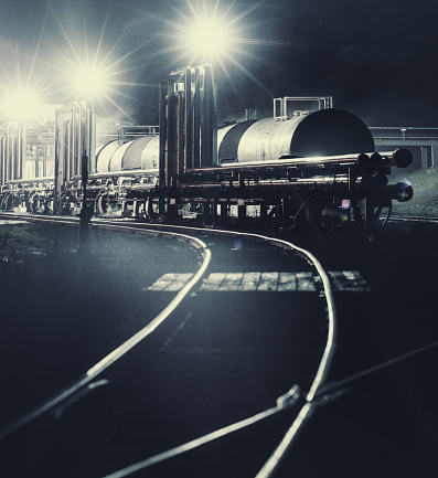 Bright lights illuminate a chemical plant as rail cars are loaded with byproduct.  Long exposure.