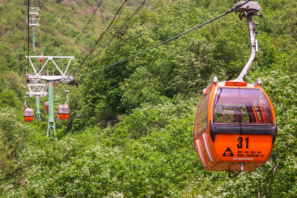 Cab of orange colour of cableway on the background of Mountain landscape MUTIANYU, HUAIROU, CHINA - May 7, 2018: Cab of orange colour of cableway on the background of Mountain landscape of the site of the Great Wall of China Mutianyu mutianyu stock pictures, royalty-free photos & images
