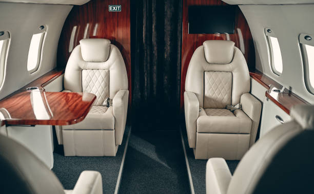Cabin of private jet Cabin of luxury private jet. Empty aircraft with white leather chairs. private airplane stock pictures, royalty-free photos & images