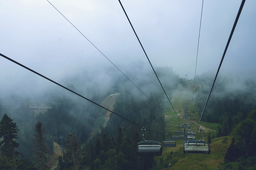 Cable car in the mountains with clouds or fog.View from the cable car to the mountain landscape.The Caucasus Mountains.without people, suitable for advertising outdoor activities and sports.copy space