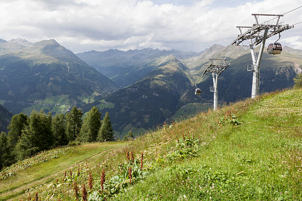 Cable car with view of Austrian Alps in background. "Cable car going up from Defereggental to Leppleskofel during summer season with mountain landscape and valley in background, Tyrol, Austria." osttirol stock pictures, royalty-free photos & images