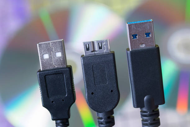 USB cable plug faces with tech background stock photo
