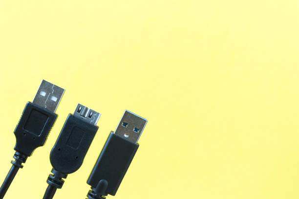 USB cable plug faces with yellow background stock photo