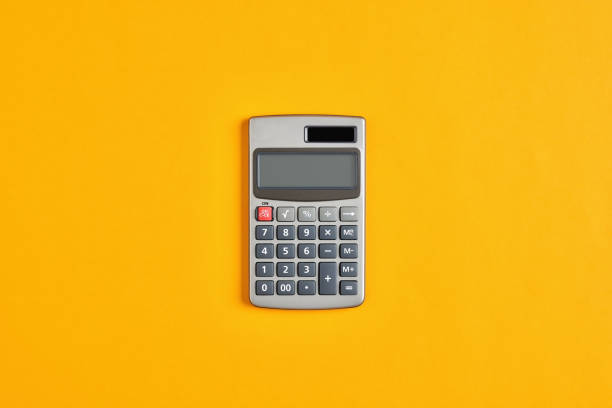 calcolatrice su sfondo giallo. calcolo in economia, finanza o istruzione - calcolatrice foto e immagini stock