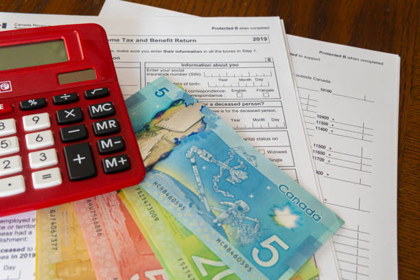Calculator with Canadin Dollar notes and Canadian new 2019 Tax Form stock photo