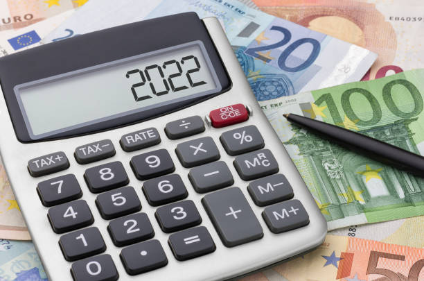 Calculator with money and a pen - 2022 stock photo