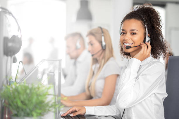 Call center worker accompanied by her team. stock photo