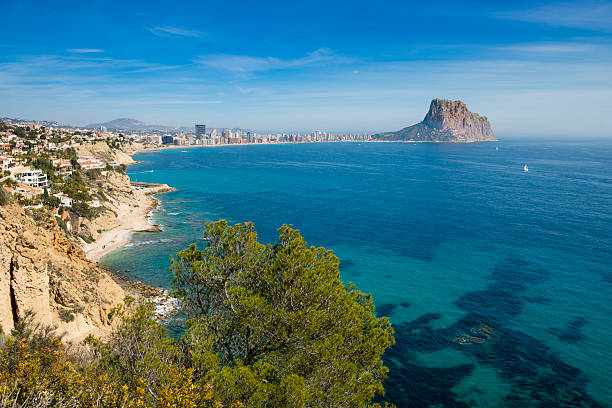 Calpe coast and Penon de Ilfach View along the Mediterranean Coast to Calpe and Penon de Ilfach, showing villas, cliffs and beaches and the main developments of Calpe town calpe stock pictures, royalty-free photos & images