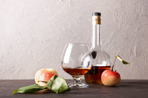 calvados in a bottle and glass on a wooden board space for text calvados in a bottle and glass on a wooden board space for text calvados stock pictures, royalty-free photos & images
