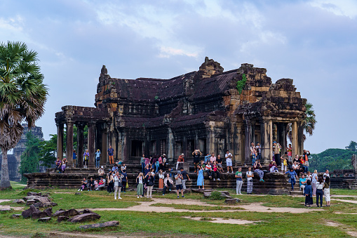 Cambodia. Siem Reap Province. A crowded group of tourists take a photo of Angkor Wat (Temple City), a Buddhist and temple complex in Cambodia and the largest religious monument in the world