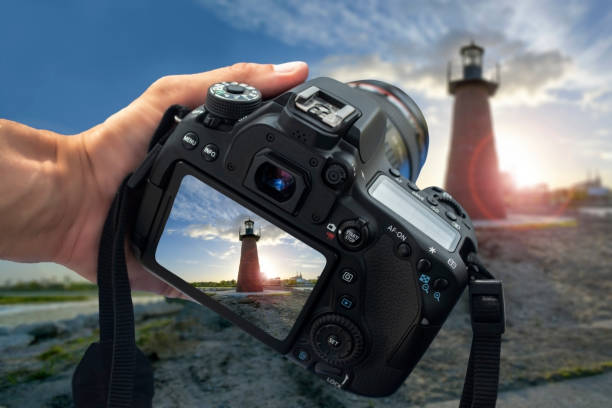 A DSLR camera held by one hand stock photo