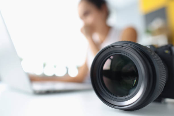 lente de la cámara en el fondo de la mujer que trabaja en la computadora - video editing fotografías e imágenes de stock