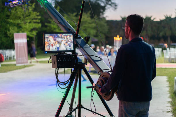 A camera man operating a camera jib during the wedding. stock photo