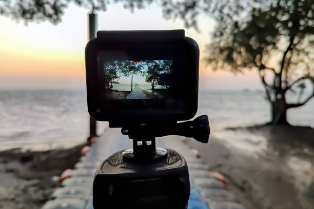 Camera mounted on a tripod photograph the pier and sunrise. Close up, view on screen, stock photo